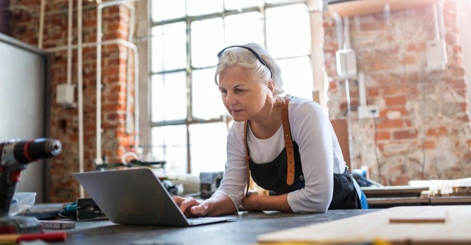 woman in an apron typing on a laptop
