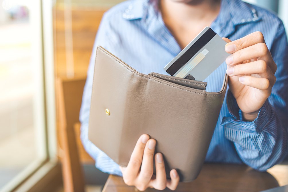 person placing debit card into wallet