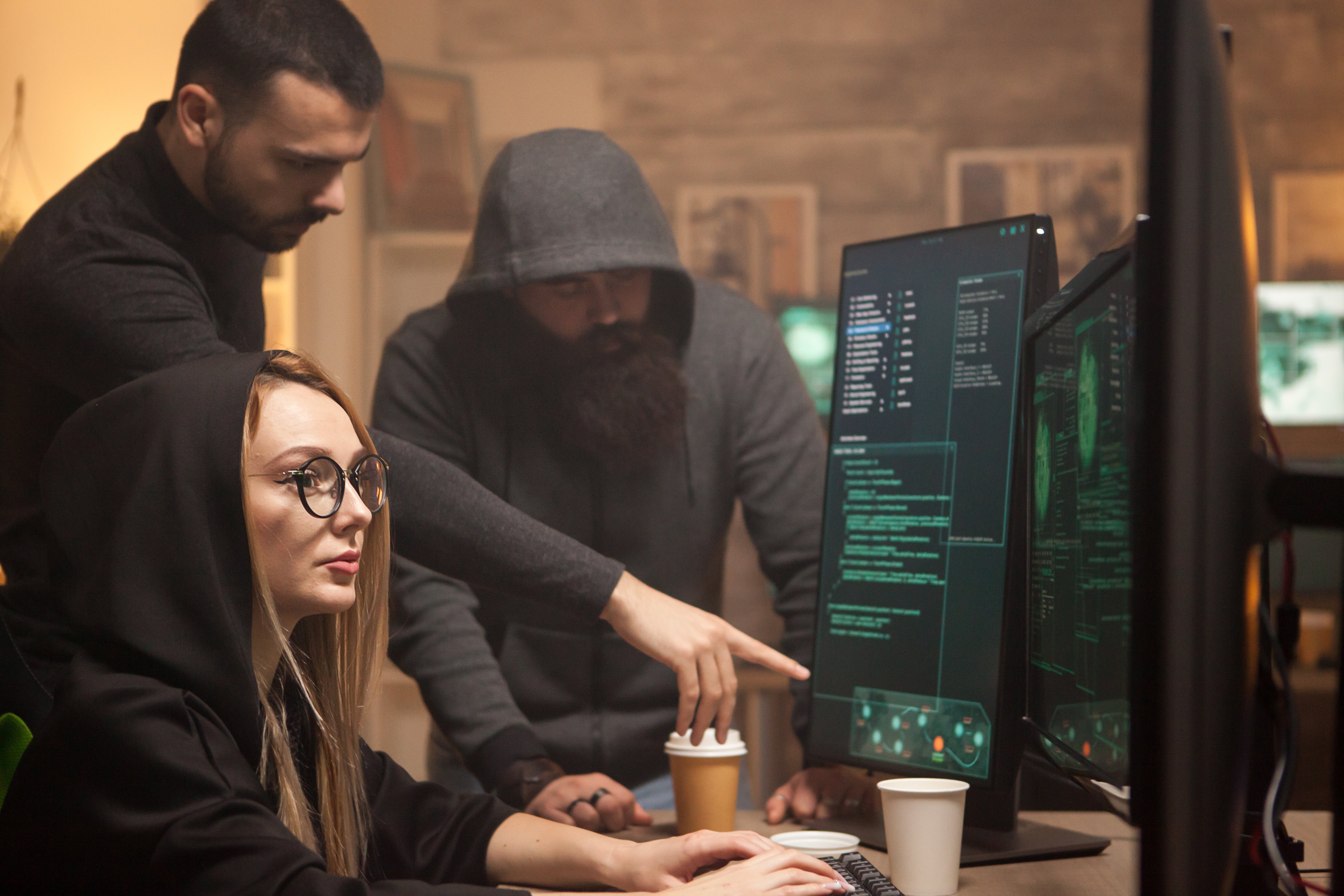 people in dark hoods representing hackers